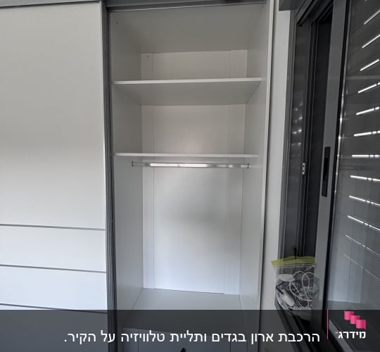ארון בגדים עם מדפים ומגירות ליד חלון